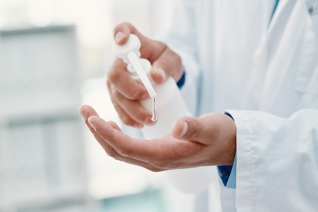 Pour ma sécurité et pour la vôtre Photo recadrée d'un scientifique se désinfectant les mains avec un désinfectant pour les mains dans un laboratoire