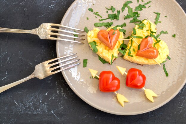 Pour le petit déjeuner le jour de la Saint-Valentin peut être omelette avec du pain en forme de coeur.