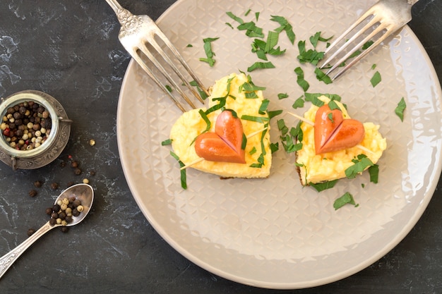 Pour le petit déjeuner le jour de la Saint-Valentin peut être omelette avec du pain en forme de coeur.