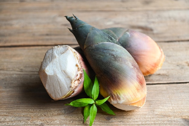 Pousses de bambou crues fraîches avec des feuilles pour la cuisson des aliments en thaïlande Pousses de bambou sur fond de table en bois