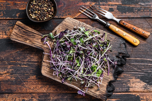 Pousses de cresson Microgreen crues sur une planche à découper