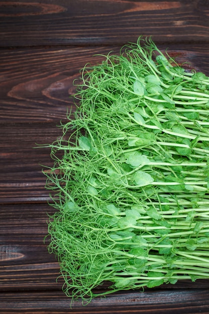 Pousses de pois microgreen hachées sur la vieille table en bois