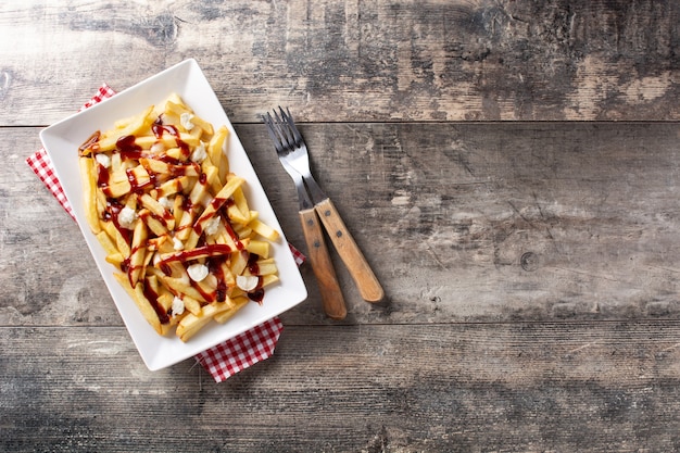 Poutine canadienne traditionnelle sur table en bois