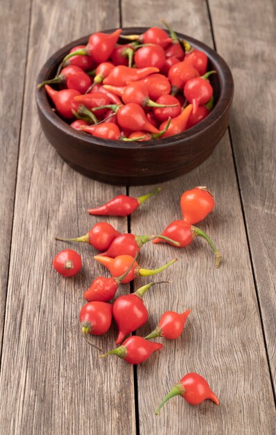 Poutre au poivron rouge sur un bol sur une table en bois.