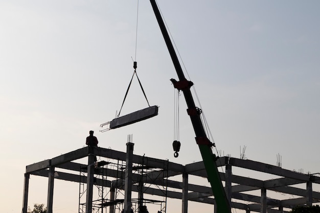 Poutre en béton préfabriqué installée sur chantier par grue mobile ; formation en génie civil