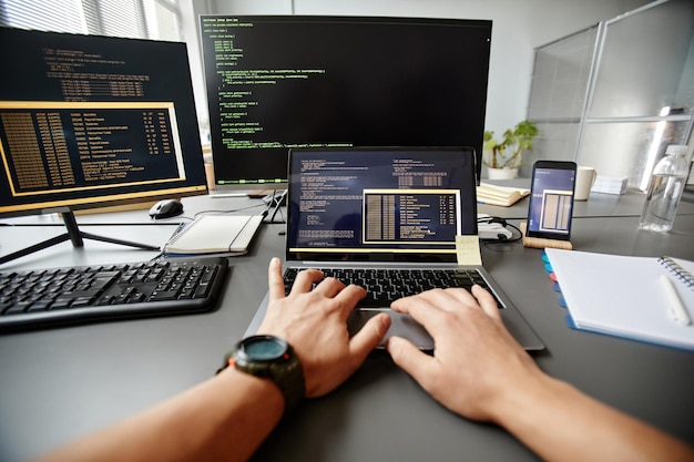 Pov d'ingénieur qa tapant sur le clavier tout en utilisant l'ordinateur sur le lieu de travail dans l'espace de copie de bureau