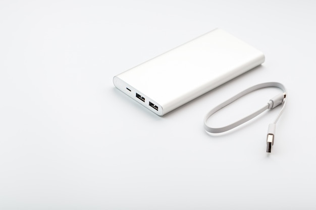 Power Bank pour charger votre smartphone sur fond blanc. Batterie externe universelle pour l'espace libre des gadgets et une composition minimaliste.