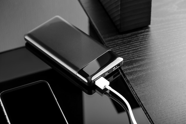 Powerbank charge un smartphone isolé sur fond noir