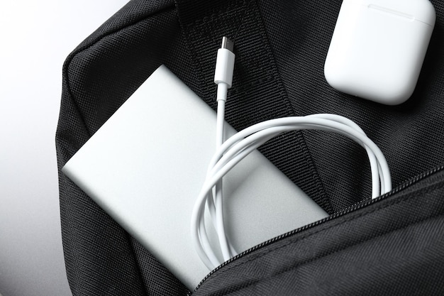Powerbank et écouteurs sans fil dans la poche du sac à dos sur fond blanc en gros plan