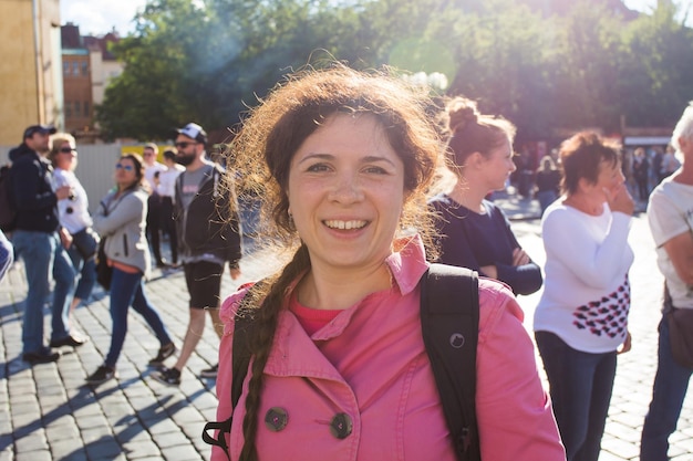 Prague, République tchèque - 7 juin 2017 : Fille heureuse en manteau rose marchant sur la vieille place de la ville de Prague.