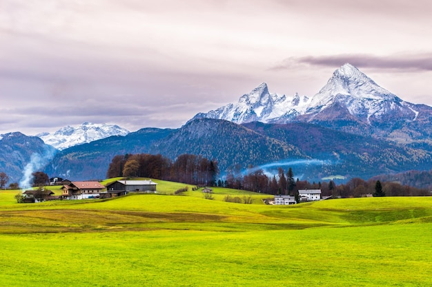 Prairie verte, maisons de fermiers et montagne enneigée de Watzmann sur fond. Concept du monde de la beauté. Alpes bavaroises. Allemagne