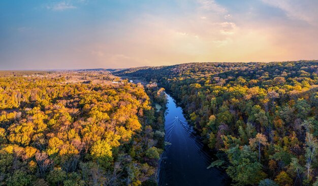 Prairies vertes et branches de rivière incurvées sous un ciel nuageux