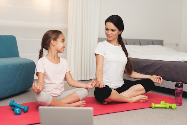 Pratique avec jeune fille et mère yoga à la maison.