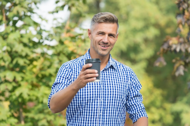 Pratique à utiliser et à transporter. Un mec heureux tient une tasse de café à emporter. Bel homme aime boire du café. Café à emporter. Boisson énergisante. Café repas le plus important de la journée.