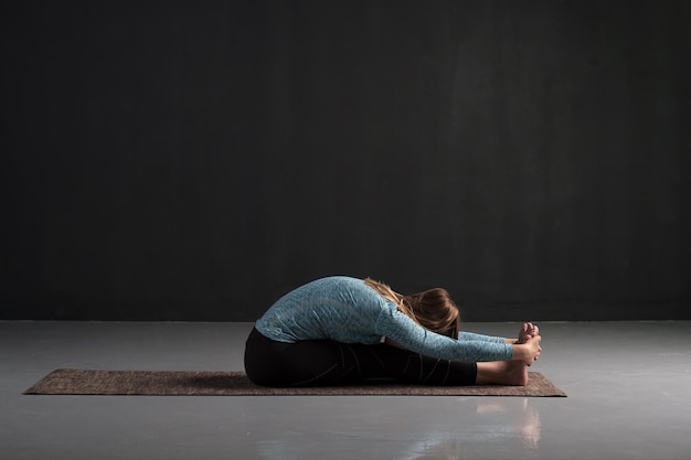 Pratiquer le yoga en faisant des exercices de paschimottanasana Pose de flexion avant assise