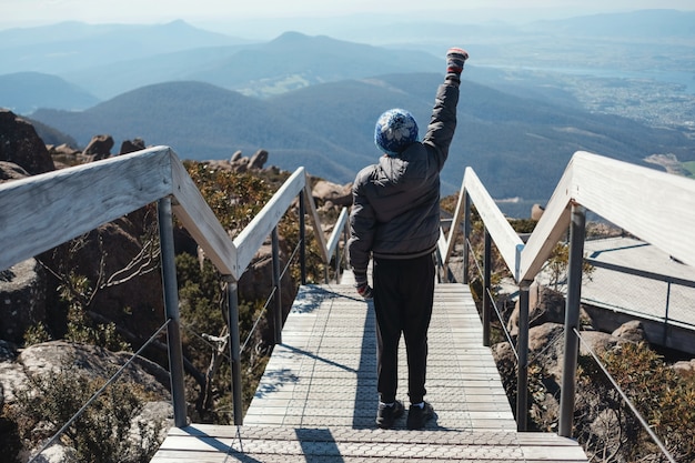 Préadolescent, debout, main, haut, montagne