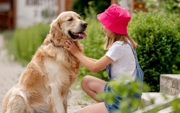 Préadolescente avec chien golden retriever