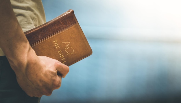 Le prédicateur chrétien Le jeune homme tient la bible en prière