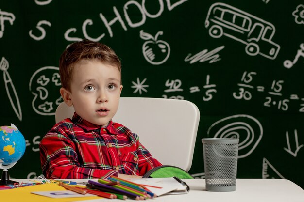 Premier jour d'école. Garçon enfant de l'école primaire. Retour à l'école. Petit garçon recueille le sac à dos scolaire à l'école. Enfant de l'école primaire.