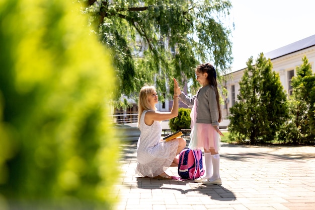 Le premier jour à l'école, une mère rencontre une petite écolière de l'école