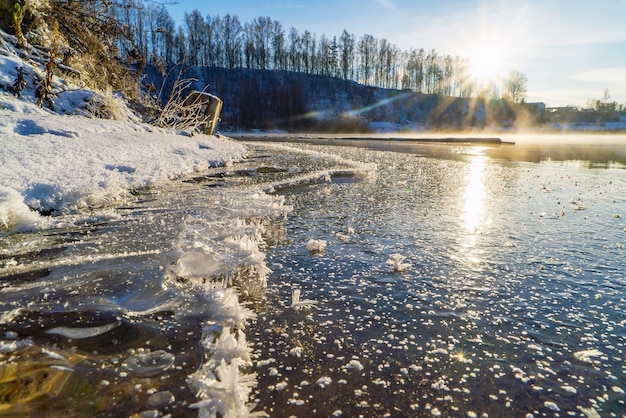 La première glace sur l'étang au petit matin glacial