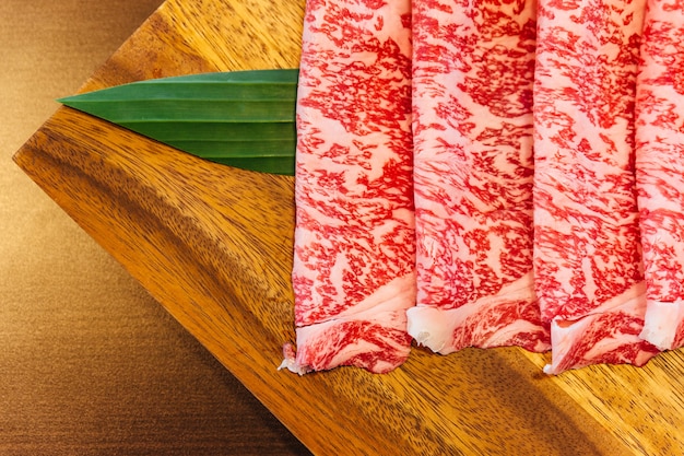 Premium Rare Slices Wagyu A5 avec texture haute marbrée sur une assiette en bois carrée