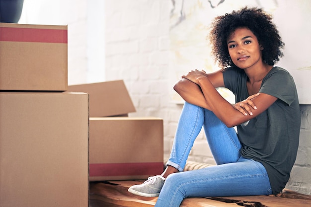 Prenant juste un moment pour réfléchir Photo d'une jeune femme emménageant dans sa nouvelle maison