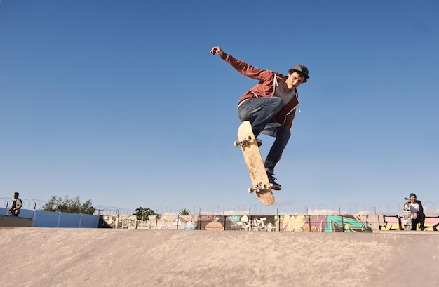 Prendre l'air Un jeune homme faisant des tours sur sa planche à roulettes au skate park