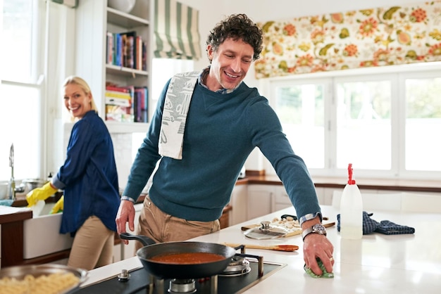 Prendre une longueur d'avance sur le nettoyage après le dîner Photo d'un couple heureux nettoyant leur cuisine ensemble après avoir préparé le dîner