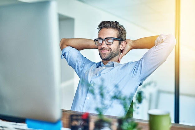 Prendre une pause bien méritée Photo d'un jeune homme d'affaires faisant une pause dans un bureau