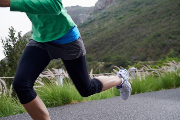 Prendre la pente Photo recadrée d'une femme sprintant le long d'une route de montagne par un matin frais