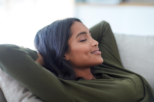 Prendre un peu de repos Photo d'une jolie jeune femme se reposant sur son canapé à la maison