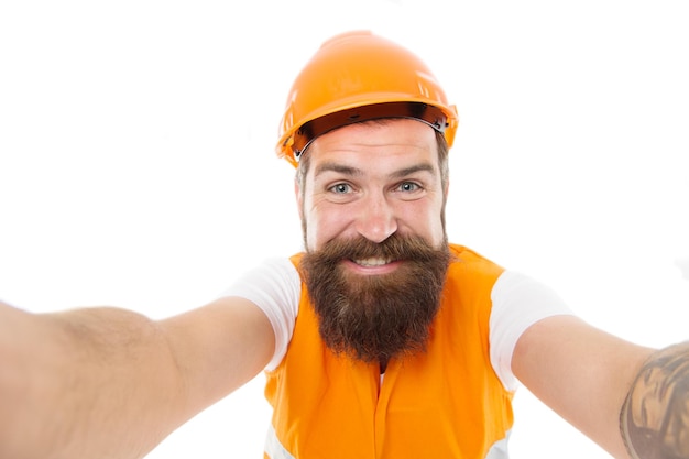 Prendre un selfie. Industrie de construction. Ingénieur de sécurité hipster barbu. Concept de carrière d'ingénieur. Ingénieur architecte constructeur. Fond blanc uniforme protecteur d'ingénieur d'homme. Après la journée de travail.