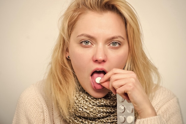 Prendre une tablette pour soulager la fièvre Concept de traitement à domicile Fille prendre des médicaments pour briser la fièvre Grippe froide et mal de gorge Pilule amère à avaler Maux de tête et remèdes contre la fièvre Femme malade tenir la tablette