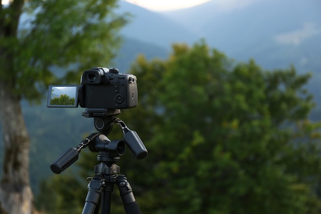Prendre une vidéo avec un appareil photo moderne sur un trépied dans les montagnes