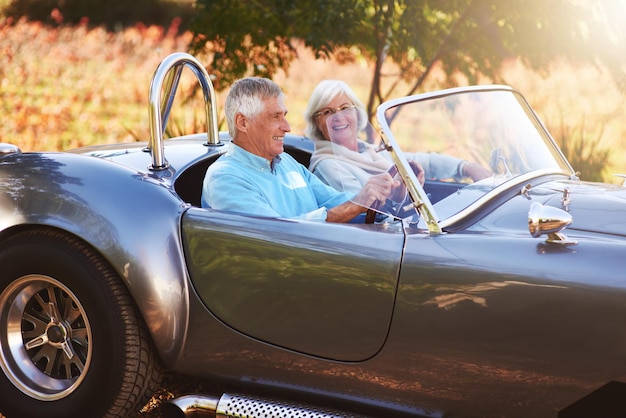 Photo prendre une voiture à travers la campagne photo recadrée d'un couple de personnes âgées conduisant à travers la campagne