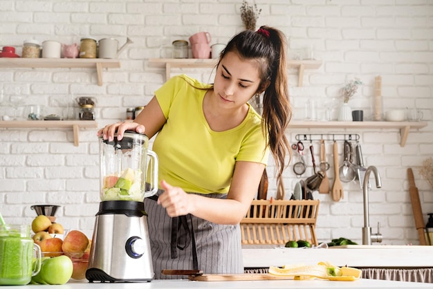 Préparation d'aliments sains Alimentation et régime sains Jeune femme brune faisant un smoothie à la banane dans la cuisine à domicile