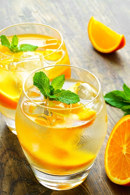 Préparation de la boisson à la limonade. Limonade dans deux verres et citron à la menthe sur la table en plein air.