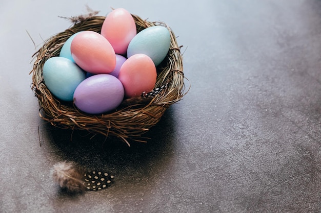 Préparation du concept de joyeuses pâques pour les oeufs de pâques décorés de pastel coloré de vacances dans le nid sur le grunge