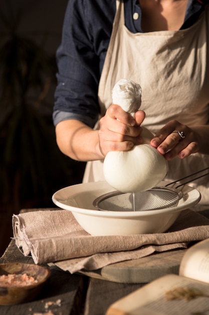 Photo préparation du lait de coco - femme filtrant le lait à travers une étamine