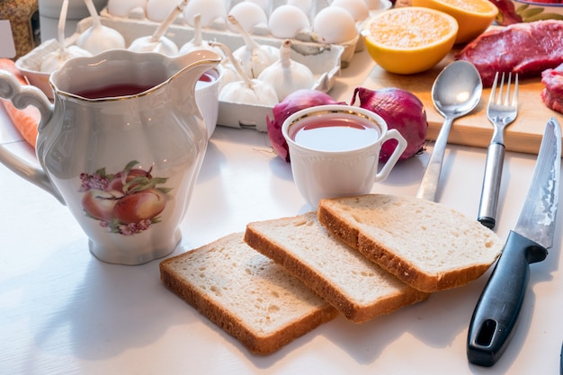 Préparation du pain avec une tasse de thé et des ustensiles de cuisine