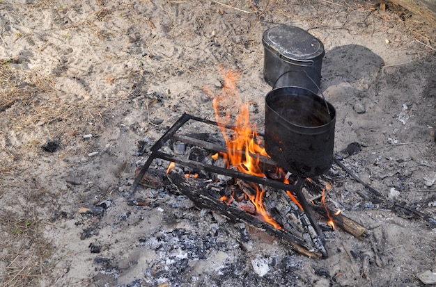 Préparation du thé sur un feu dans des conditions de terrain