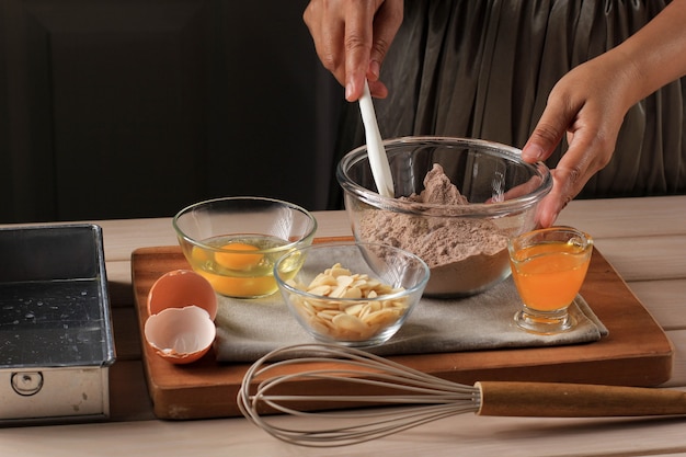 Préparation Mélangeant Le Chocolat Fondu Et La Poudre De Cacao Dans Un Bol Pour Faire De La Pâte Pour Un Délicieux Gâteau Au Brownie Sur Une Table En Bois Rustique Avec Un Fouet