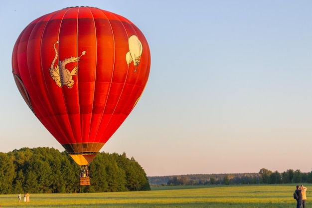 Préparation de la montgolfière avant le départ. Énorme ballon coloré au sol avec des trucs.