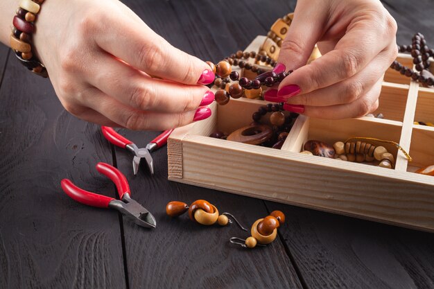 Préparation de perles à la main sur table en bois