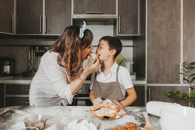 Préparation d'un petit déjeuner en famille. mère et enfant fils mangent des biscuits