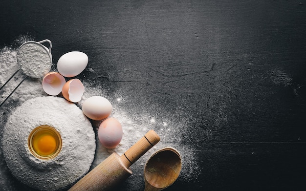 Préparation pour la cuisson des œufs avec un rouleau à pâtisserie Sur la table en pierre Espace libre pour le texte Vue de dessus