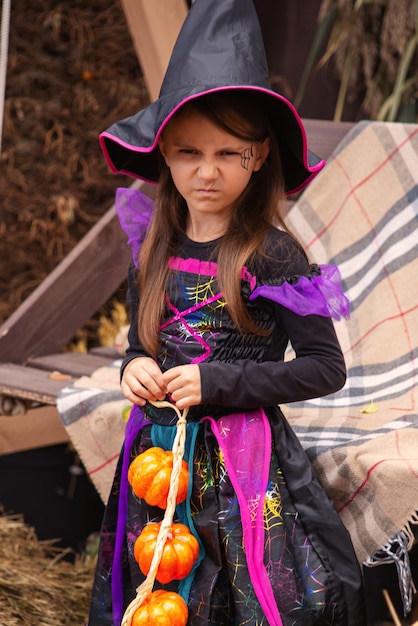 Préparation pour Halloween Une fille vêtue d'une robe de sorcière maléfique et d'un grand chapeau Elle est de bonne humeur