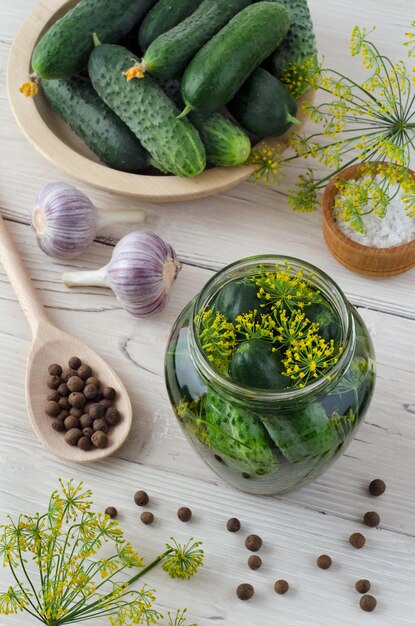 Préparation pour mariner les concombres dans un bocal en verre avec des épices et des herbes. Vue de dessus.