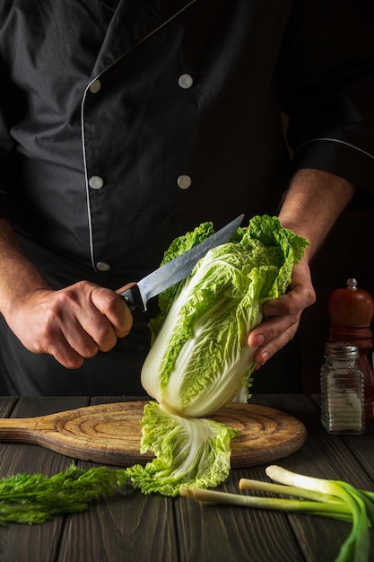 Préparation de la salade de chou Napa Chef tout en travaillant dans la cuisine du restaurant